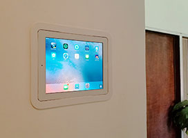 iPad mounted on the wall as an entertainment and security system